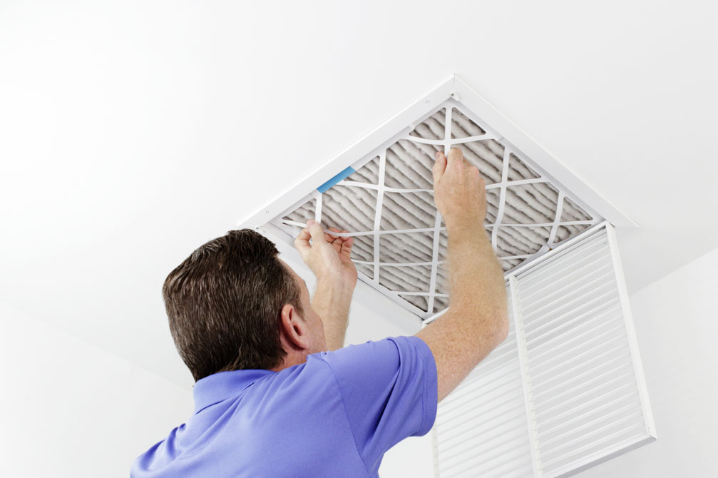 Indoor Air Quality Technician changing A/C filter