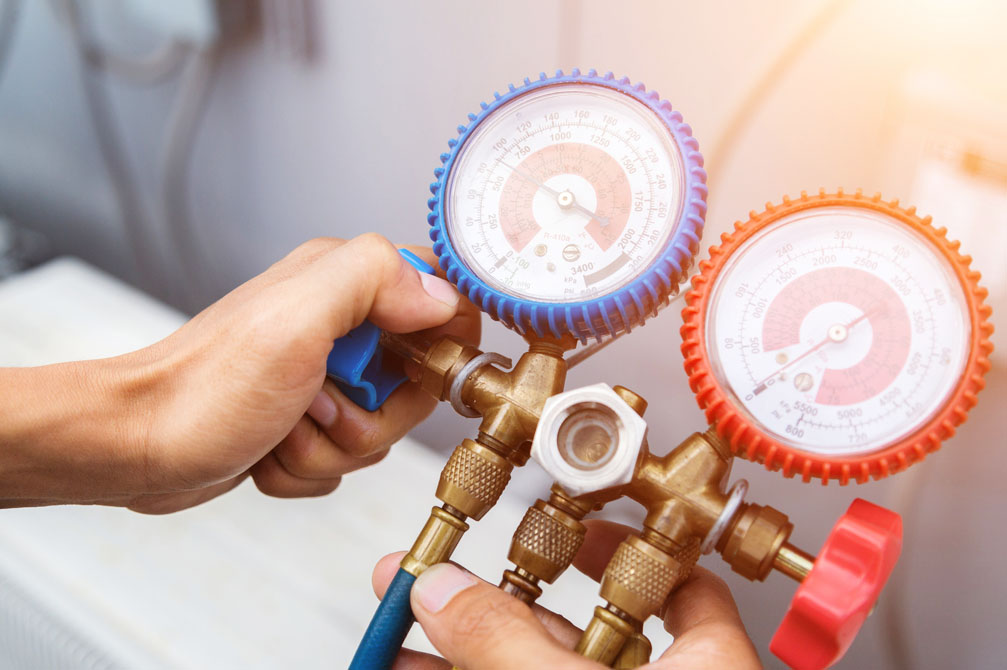 Technician with A/C diagnostic tools in hand